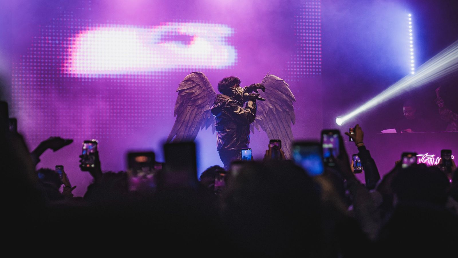 Najm avec des ailes sous les lumières violettes