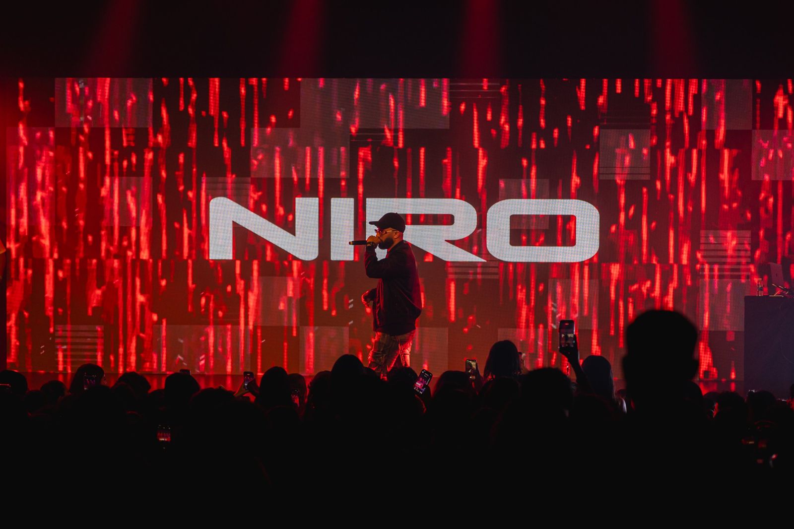 Niro devant l'écran géant rouge à son nom